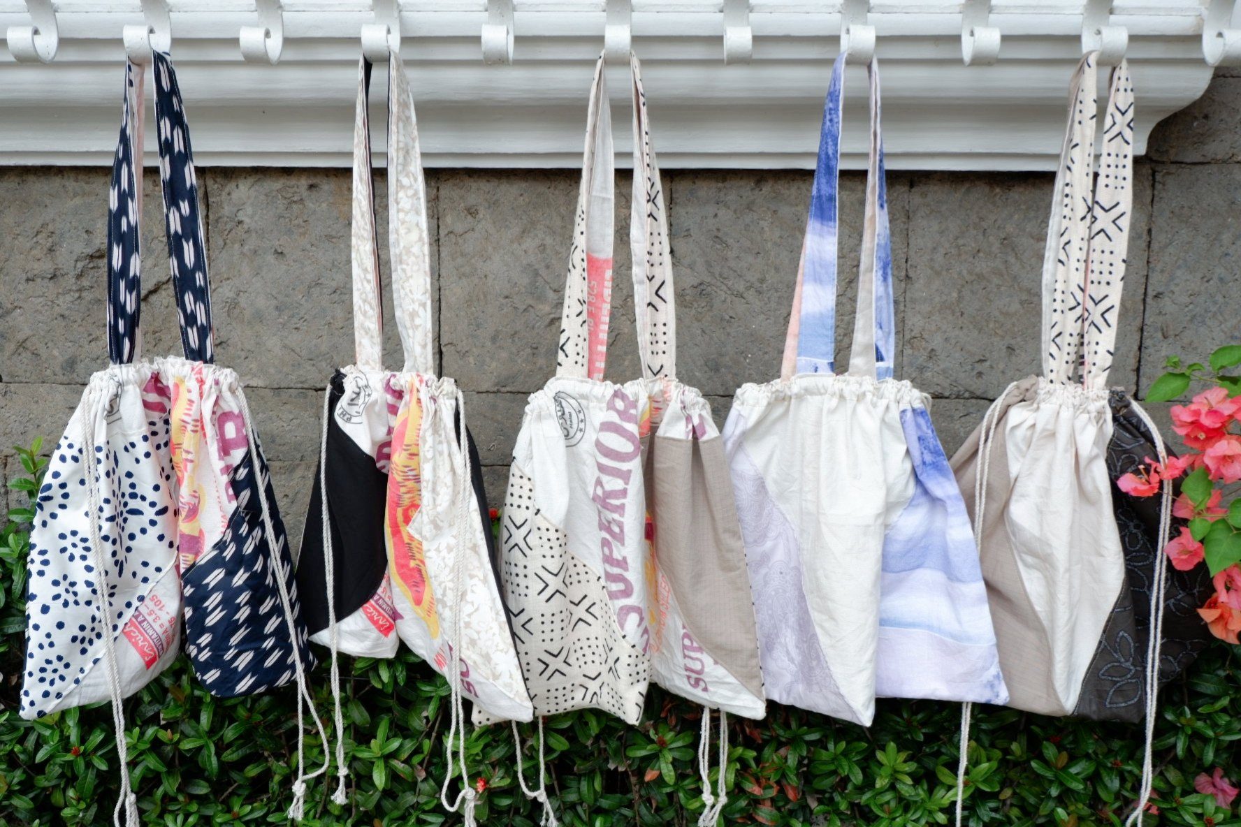A row of upcycled drawstring totes