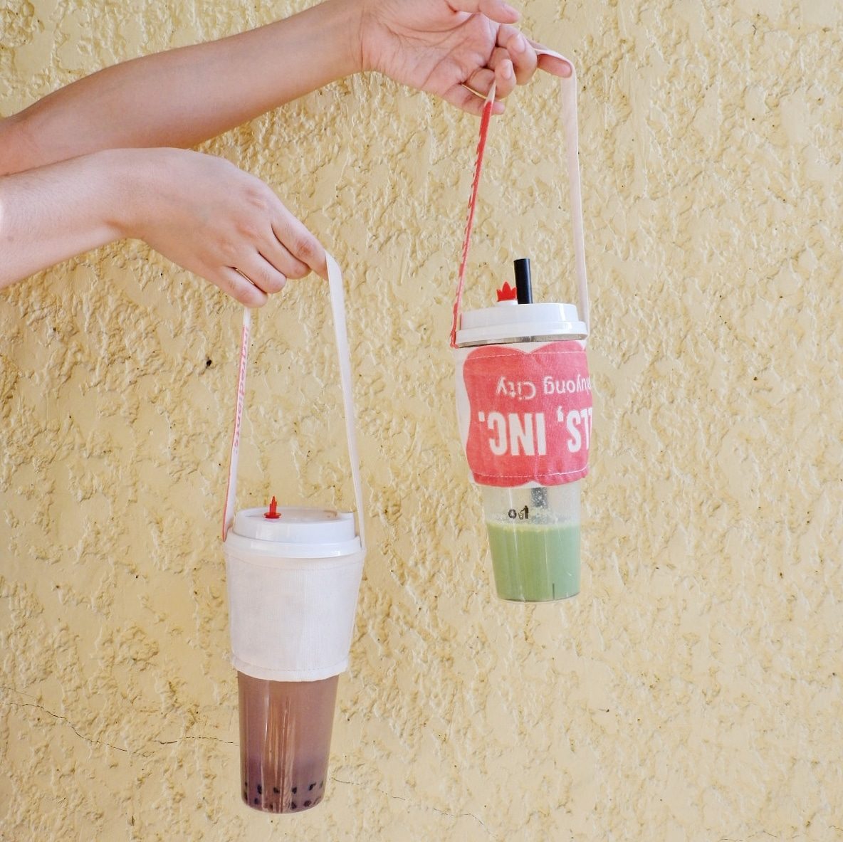 Two upcycled katsa drink carriers holding milk tea cups