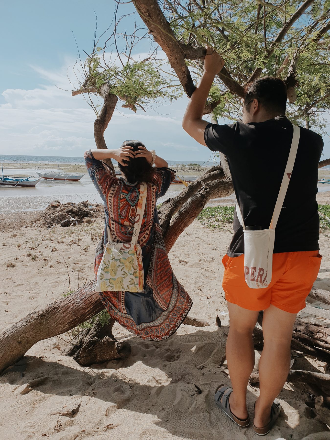 A couple carrying katsa bags on the beach